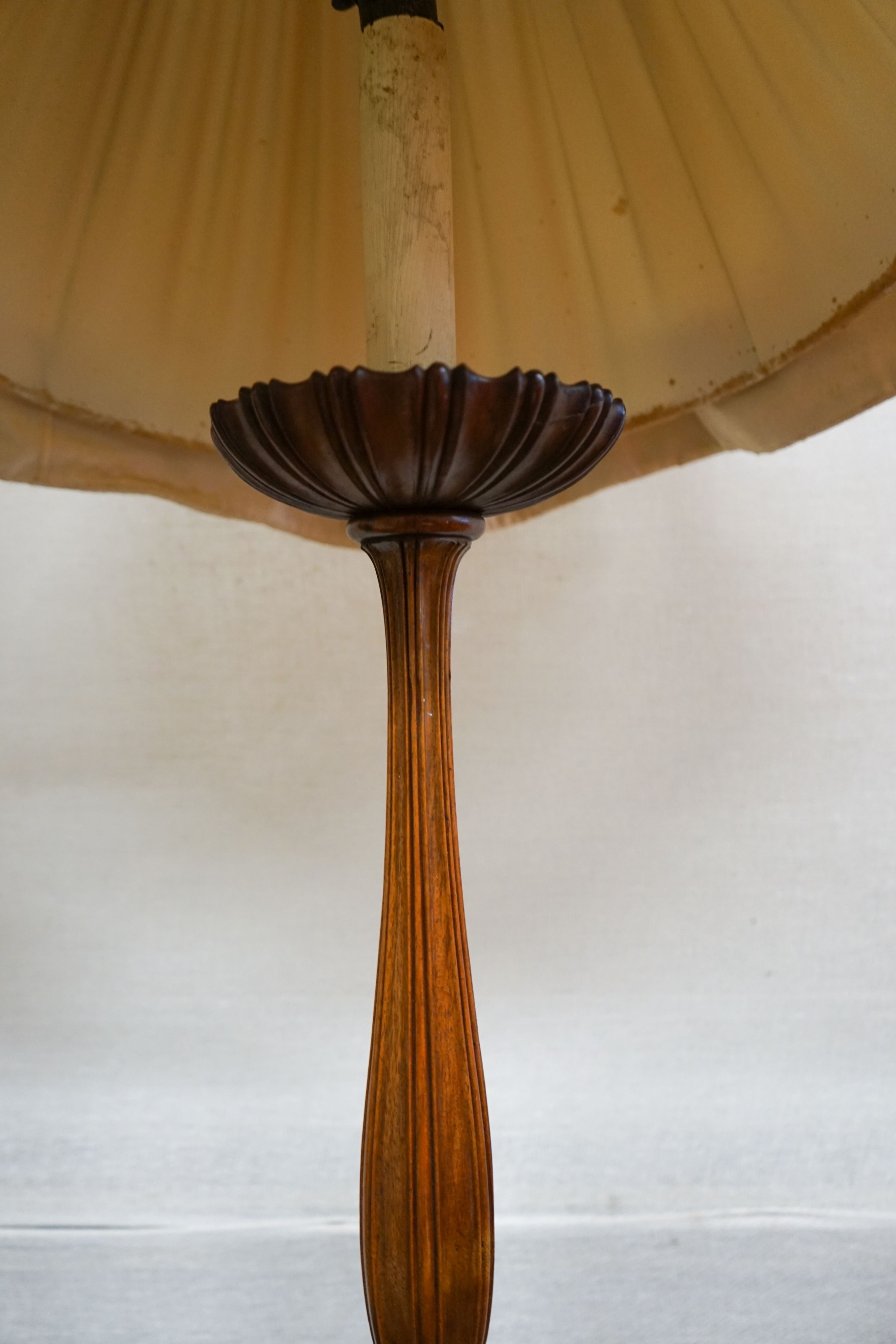 A turned and carved walnut standard lamp on circular base with bun feet, height excluding shade 132cm